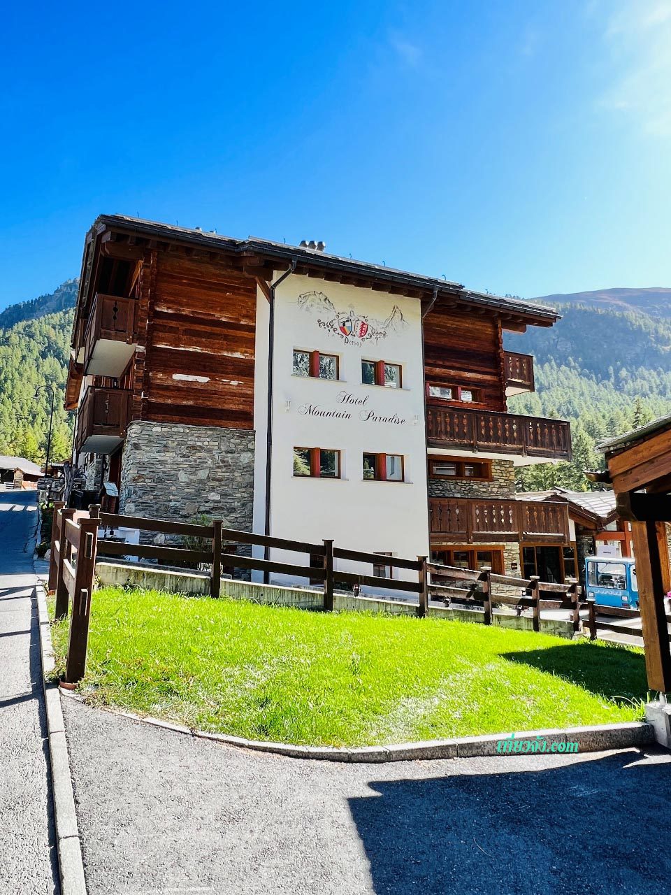 โรงแรม Mountain Paradise Zermatt สวิตเซอร์แลนด์ สไตล์ชาเลต์ไม้และหิน ท่ามกลางเนินเขาเขียวขจีในวันที่มีแดดจ้า ใกล้ทางเดินขึ้นเขา Matterhorn